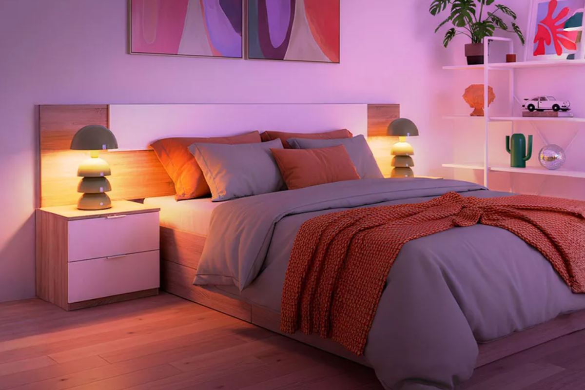 vista de canapé con colchón de matrimonio, en habitación decorada con mesitas de noche y lámparas encendidas