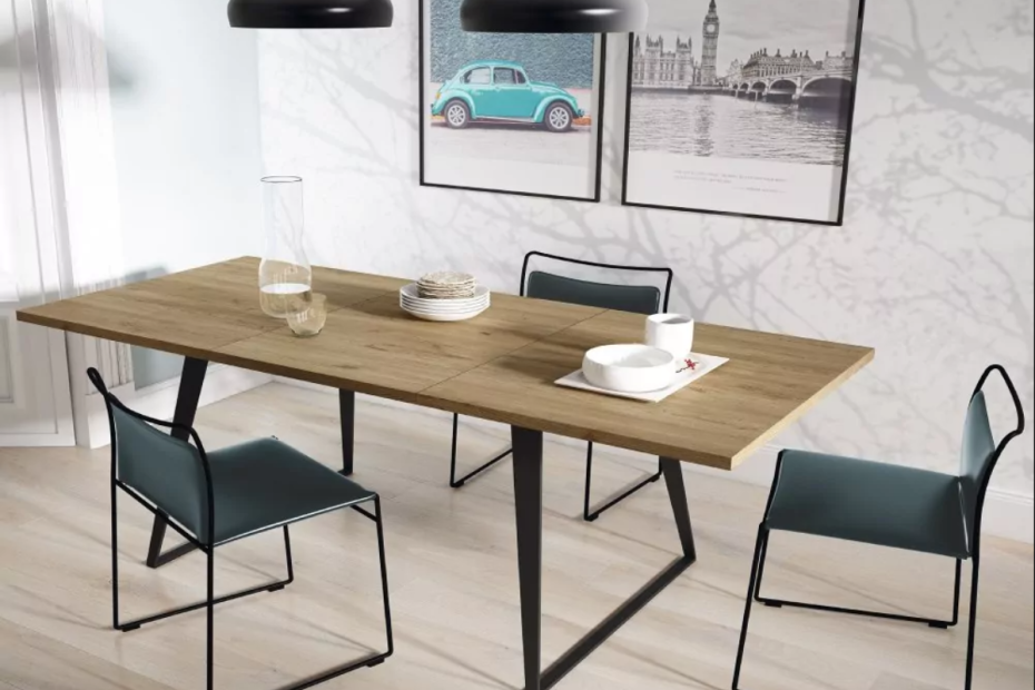Mesa de comedor extensible rectangular, tonos amaderados, decorada con dos sillas negras, un jarrón vacío y dos tazas