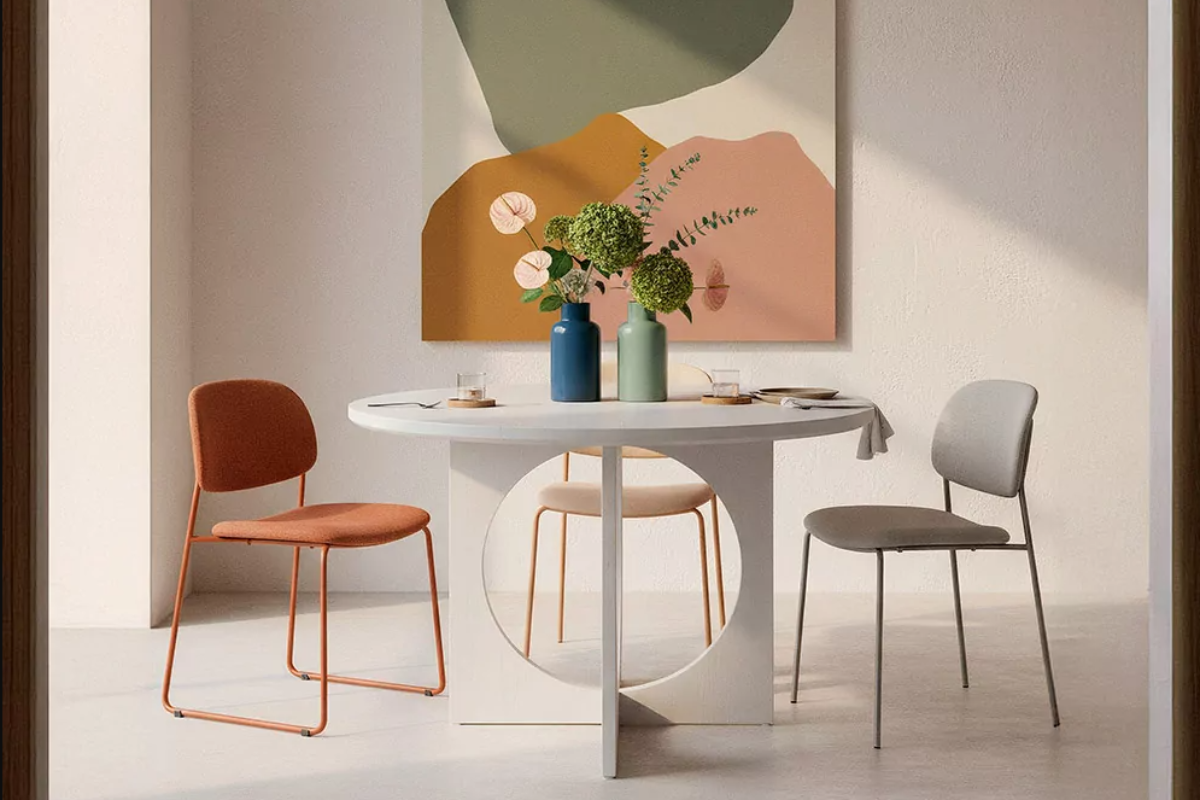 mesa de comedor redonda blanca, decorada con sillas y un jarrón con flores encima