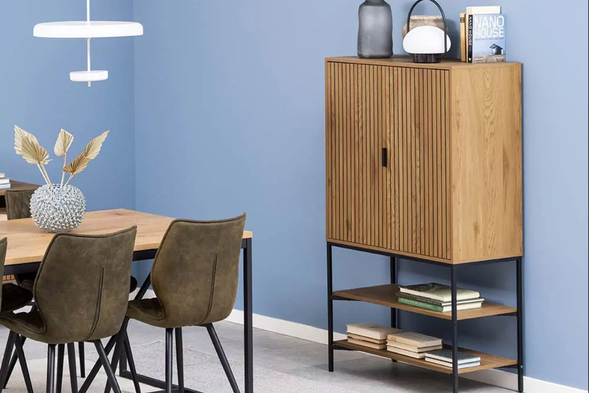 aparador alto de dos puertas color madera, con patas y con bandejas de almacenamiento, decorado con libros encima
