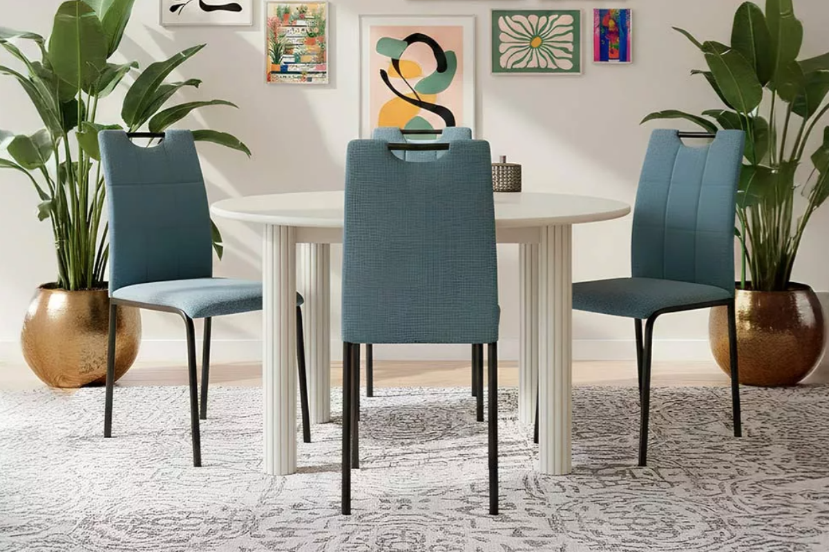 tres sillas de comedor tapizadas azules, con patas metálicas, alrededor de una mesa de comedor redonda