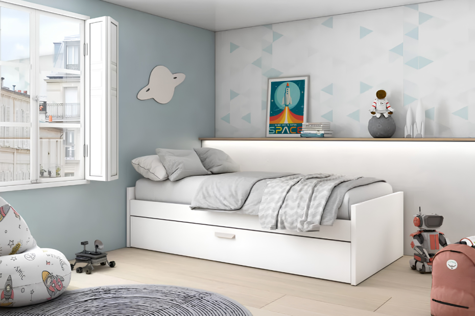 Cama nido blanca de arrastre, decorada con cojines y manta. Encima, una balda con objetos juveniles.