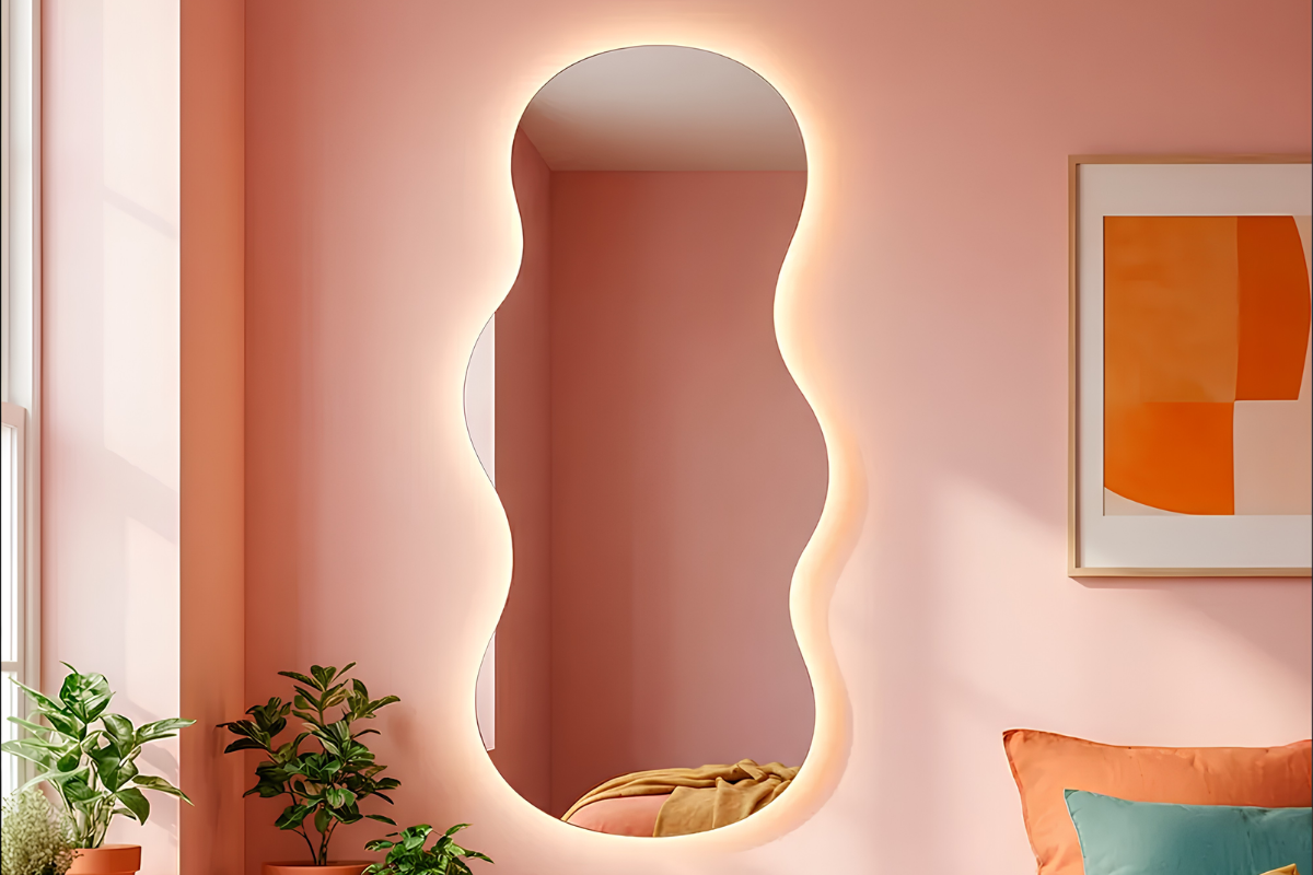 espejo ondulado colgado en pared rosa en una habitación de matrimonio, con las luces encendidas.