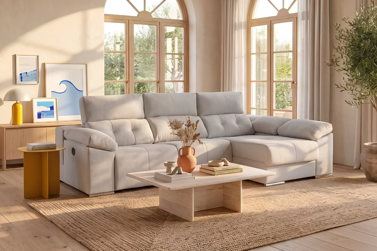 sofá chaiselongue beige decorado con mesa de centro y alfombra natural en salón amplio con grandes ventanales